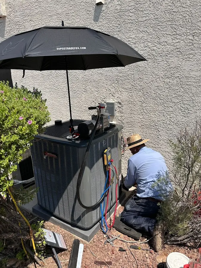 HVAC technician performing outdoor AC maintenance in North Valley